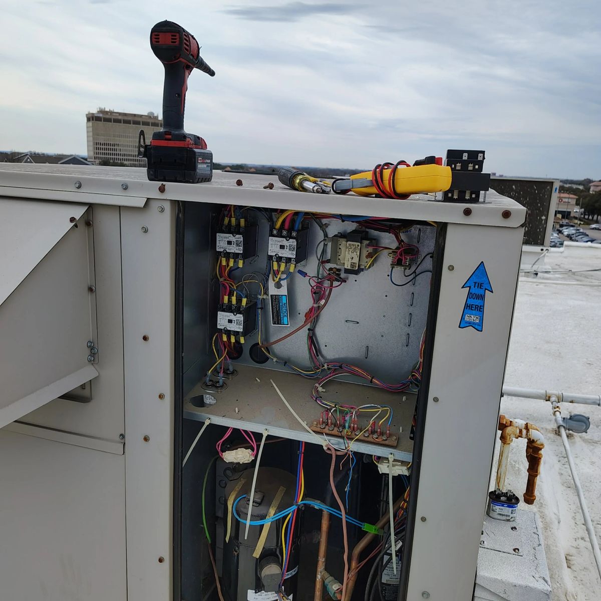 An Alvis Mechanical technician repairing a rooftop unit control panel